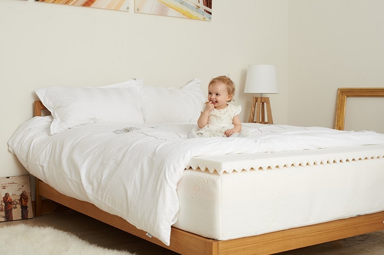 baby sitting on thick memory foam mattress 