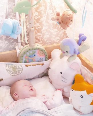 picture of baby sleeping in bed with stuffed animals