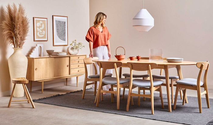 woman standing beside round wooden dining table