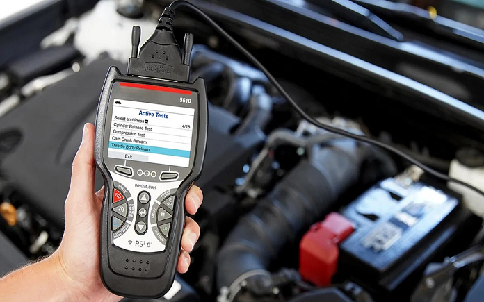 Man holding wired car diagnostic tool