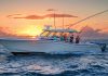 A beautiful white boat with people fishing at sunset, illustrating the ideal marine lifestyle supported by reliable marine batteries.