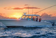 A beautiful white boat with people fishing at sunset, illustrating the ideal marine lifestyle supported by reliable marine batteries.