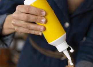 a person using a wood adhesive from a yellow bottle